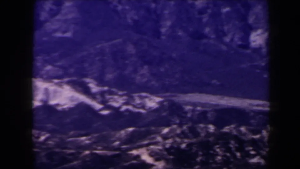 1958 Las Vegas-area 8mm frame showing a broad treeless ridge and pale diagonal rock face in bluish tint.