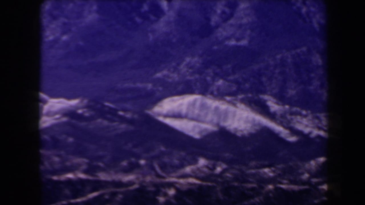 Purple-toned rocky mountain slope with pale ridges and dark 8mm frame edges.