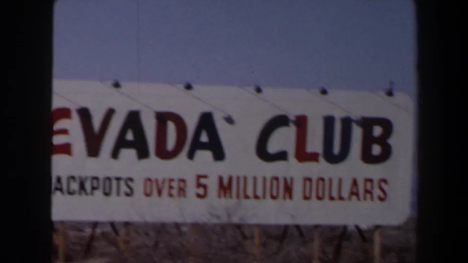 A Nevada Club sign with jackpot wording appears beside the road in 1958 Las Vegas home-movie footage.
