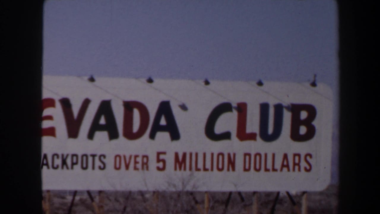 1958 Las Vegas home-movie frame showing part of a Nevada Club sign and jackpot message under a clear sky.