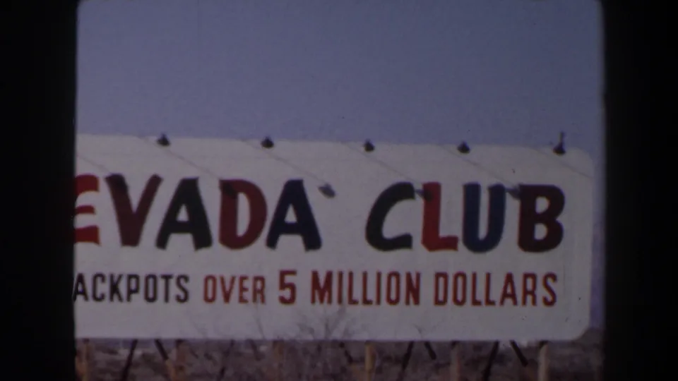 1958 Las Vegas home-movie frame showing part of a Nevada Club sign and jackpot message under a clear sky.