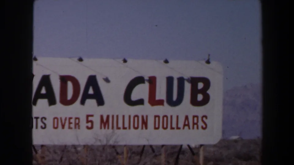 Final 1958 Las Vegas frame showing the Nevada Club sign cropped across the left edge, with jackpot advertising visible.