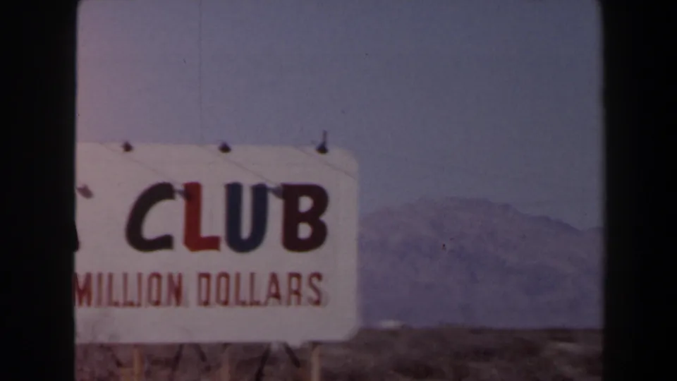1958 Las Vegas 8mm still of a partially cropped ADA Club roadside sign, with red claim text and a hazy desert mountain background.