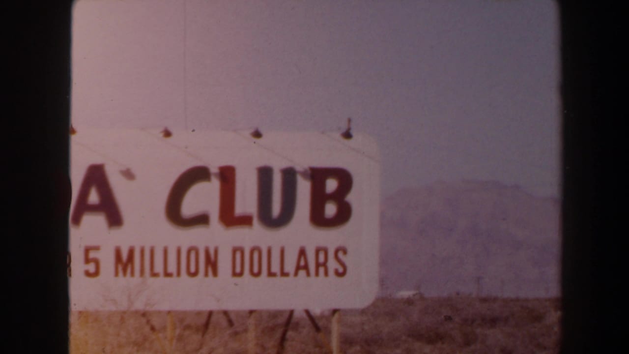 1958 Las Vegas 8mm frame showing a cropped ADA Club sign with “5 MILLION DOLLARS” visible, set before open desert and mountains.
