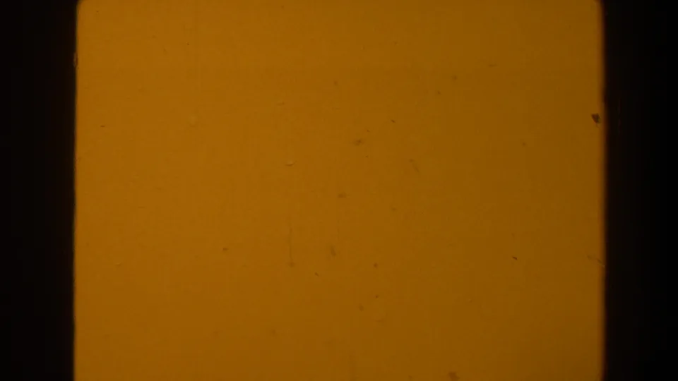 Warm orange-yellow 8mm frame from the 1958 Las Vegas clip, with dark borders and small dust marks visible.