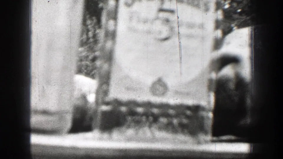 Chelan, Washington 1939 home-movie frame showing bottles on a table and a partly visible deer skull or trophy display in soft focus.