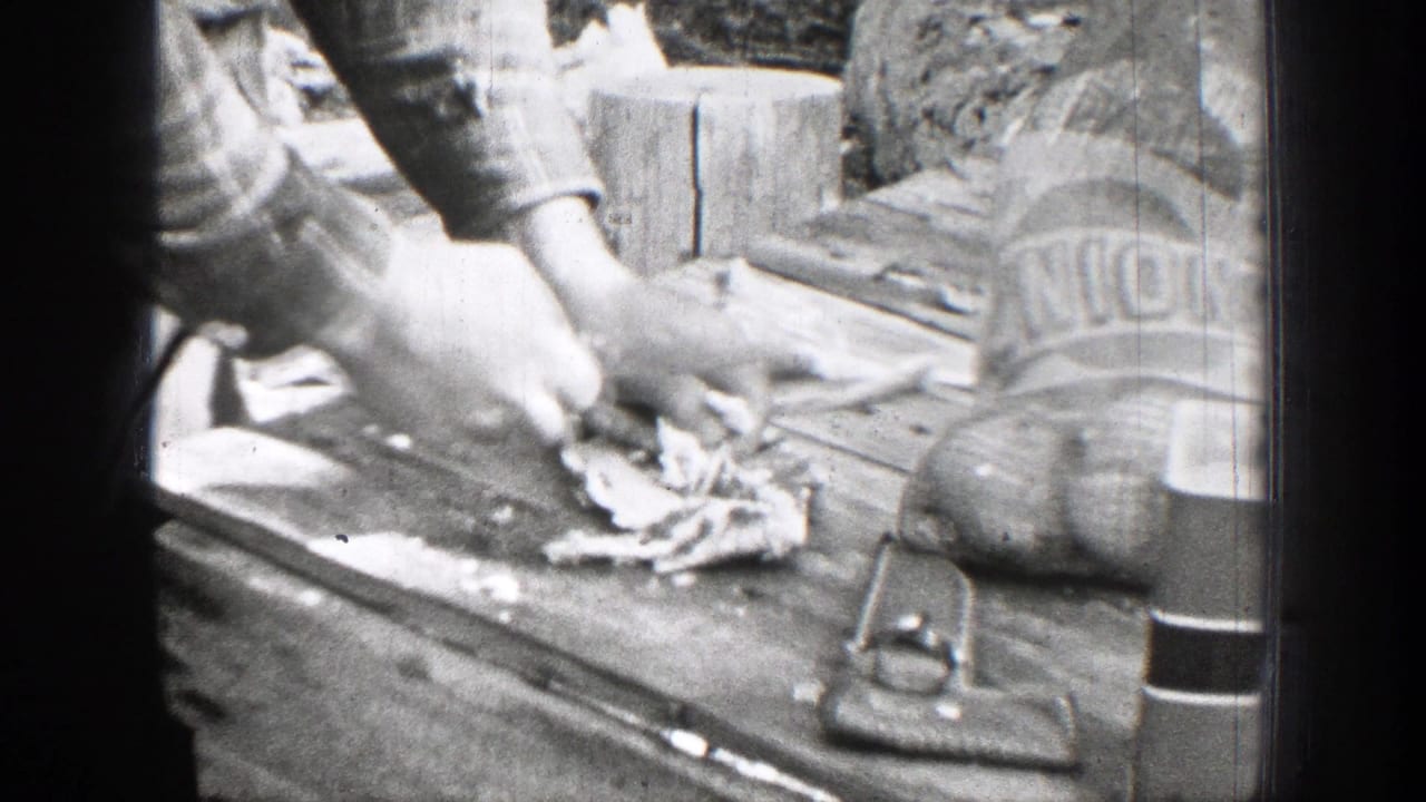 Hands cut meat on a wooden board beside cloth bags and a knife.