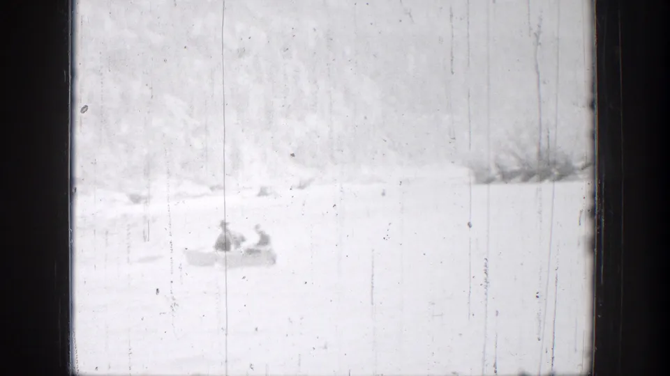 1939 Chelan, Washington home-movie frame showing two people in a small boat on calm water, with a low shoreline behind them.