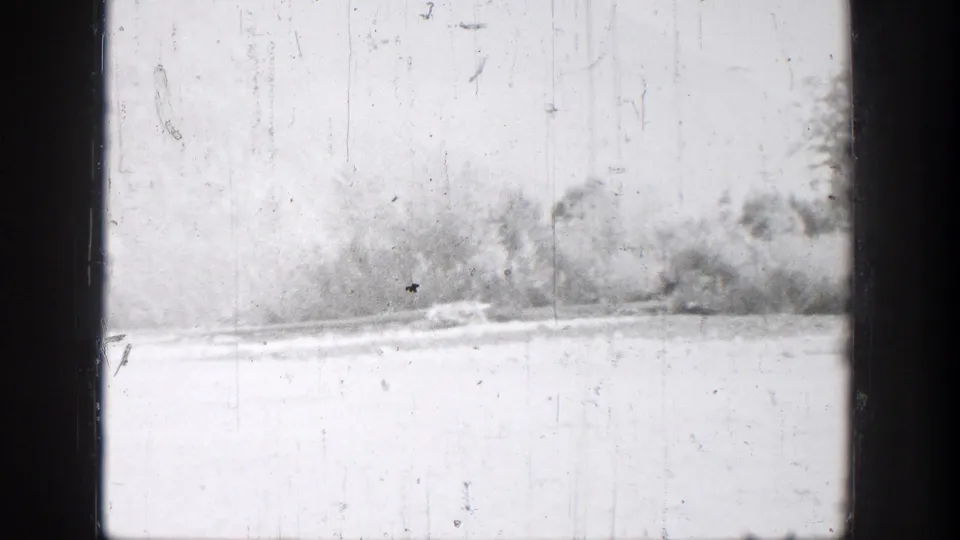 Chelan lake footage shows a washed-out foreground, distant shoreline trees, and heavy 8mm scratches in the frame.