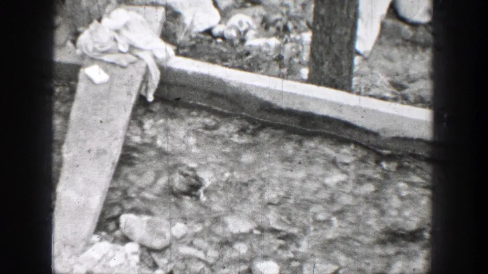 The final frame shows rocky ground with a concrete edge, vertical post, and draped cloth in the 1939 Chelan, Washington 8mm footage.