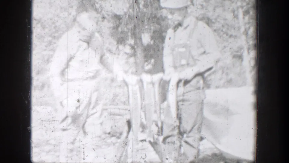 Two fishermen appear in a bright, soft 8mm frame, holding fish in a wooded Chelan-area outdoor setting.