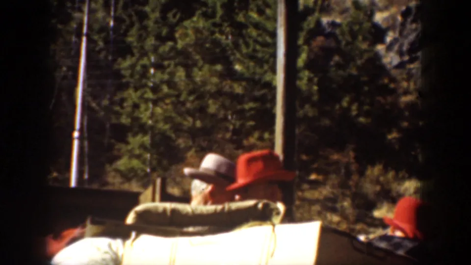 Passengers sit aboard a lake boat in Chelan, Washington, with trees and deck hardware visible in the background.