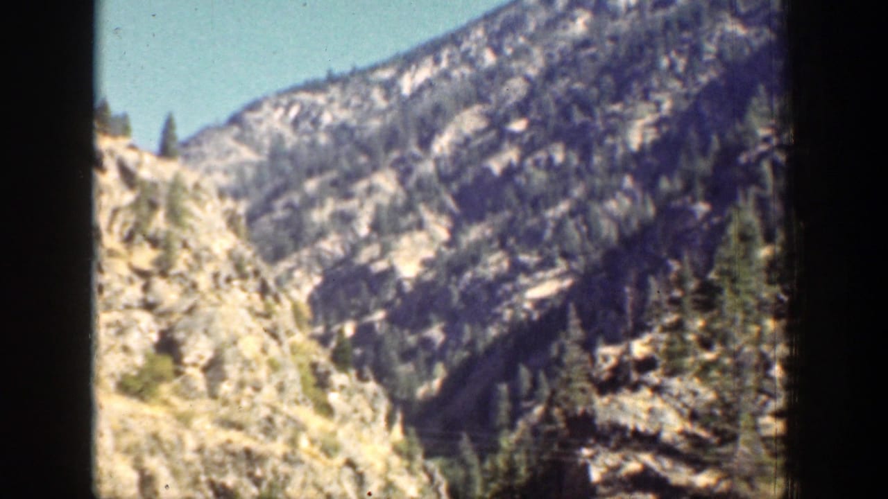 Rugged mountain terrain near Chelan, Washington appears through dark vertical framing in a 1939 8mm home-movie view.