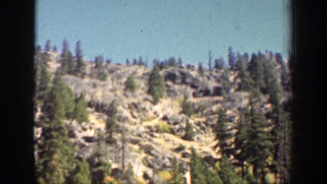 The final 1939 Chelan frame shows a rocky hillside dotted with evergreens and a ridgeline under clear daylight.