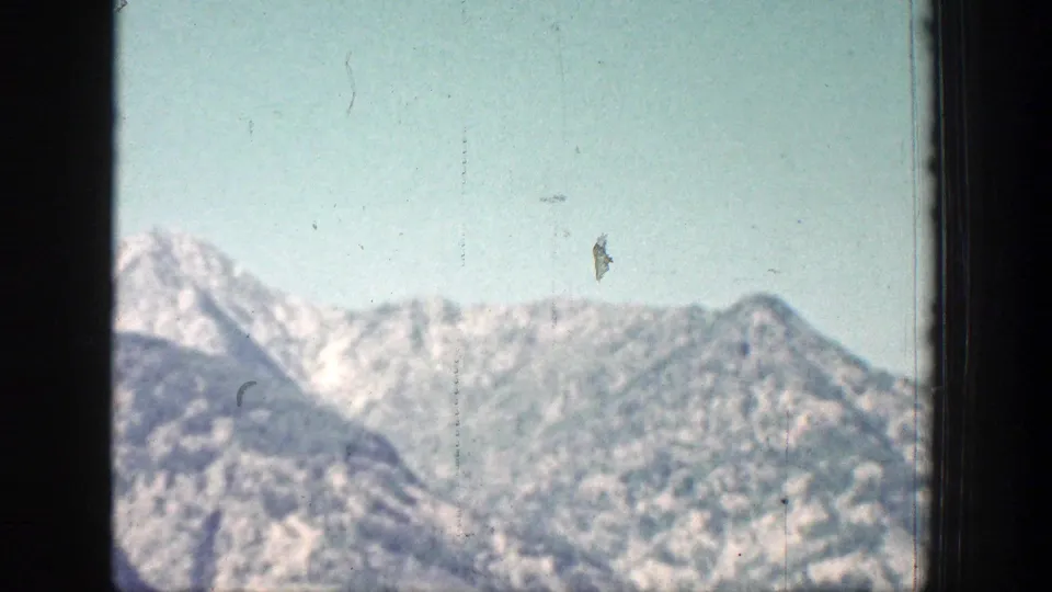 1939 Chelan-area 8mm view of a pale mountain ridge with snow traces and a dark frame edge in front.