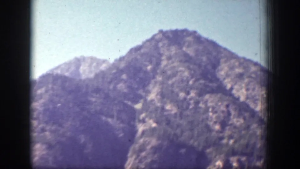 Rugged mountain peaks near Chelan, Washington, seen in soft 1939 8mm color with dark frame edges visible.
