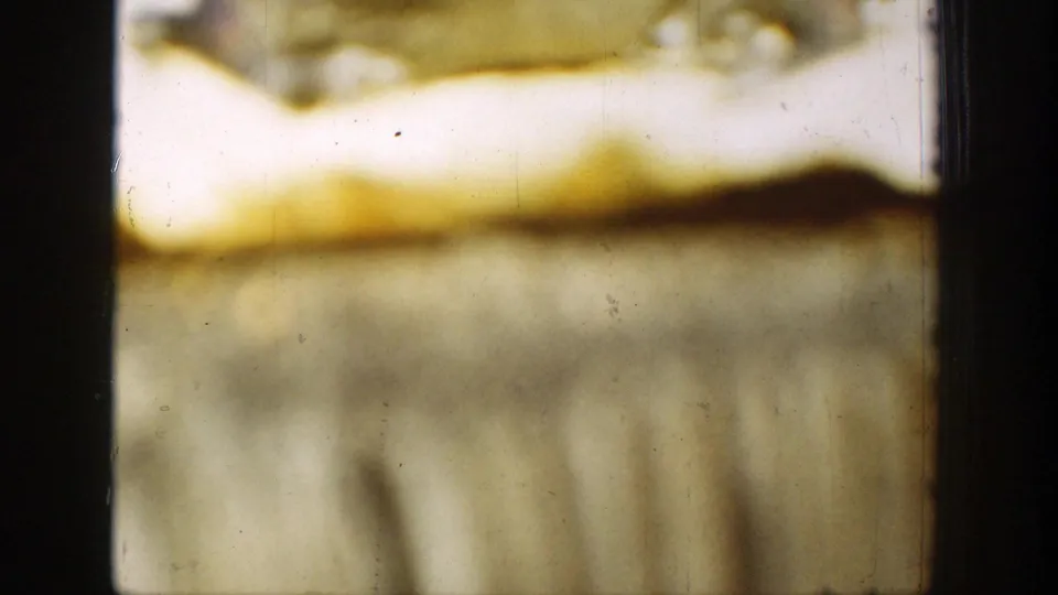 Chelan 1939 8mm frame showing the curled paper and cloth in warm, blurred exposure with scan borders and film marks.