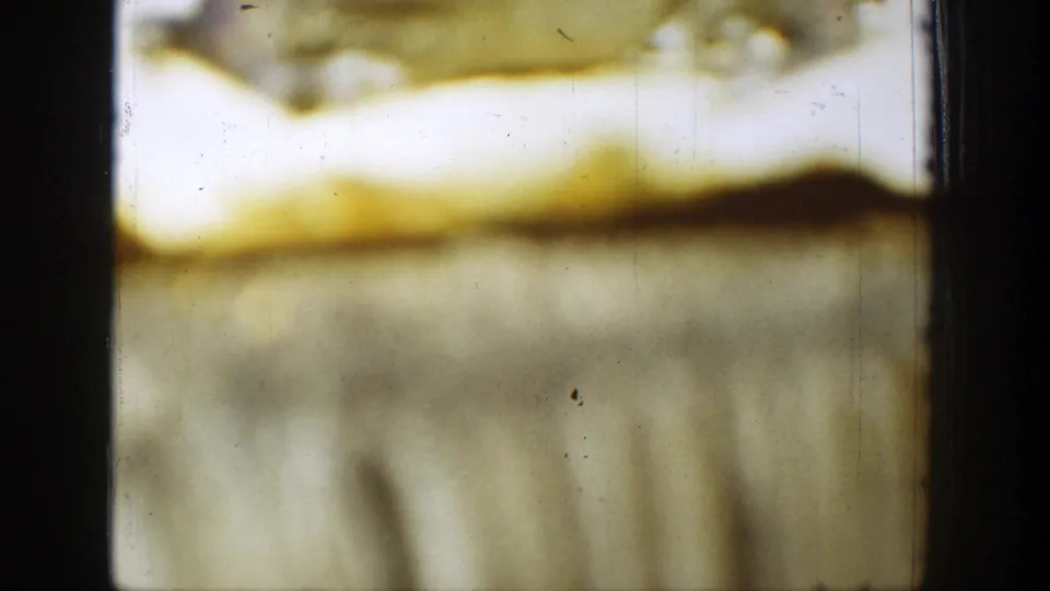 1939 Chelan 8mm frame detail showing yellow fading, soft gray-green texture, black frame borders, dust, and scratches.