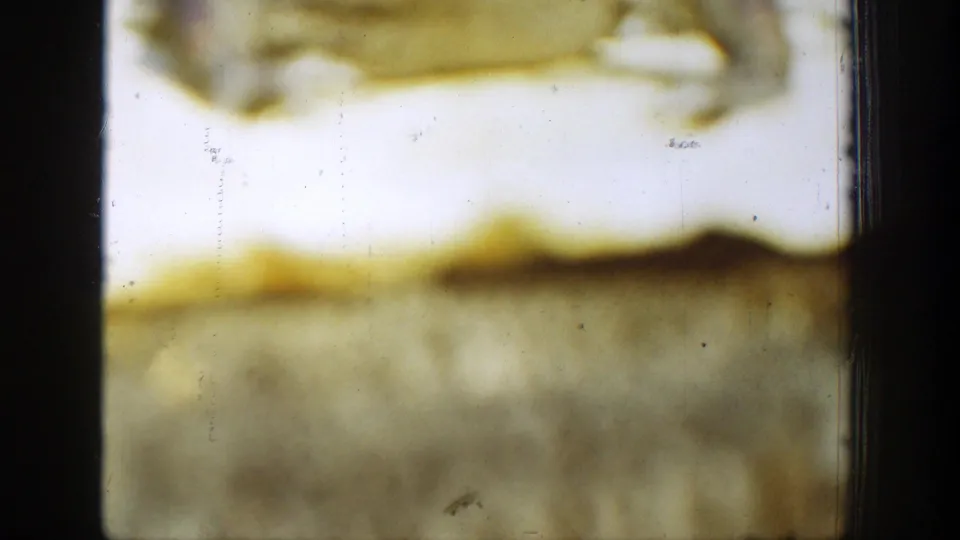 1939 Chelan 8mm detail with a dark vertical frame edge, yellow fading, pale exposure, grain, and surface marks.