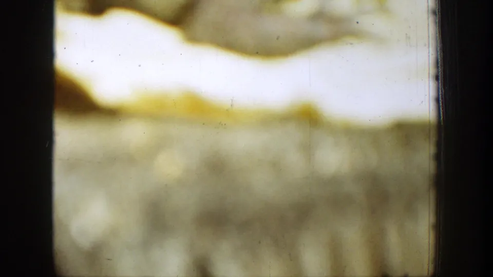 1939 Chelan 8mm frame detail showing yellow-white streaking, black borders, blurred texture, scratches, and aging marks.
