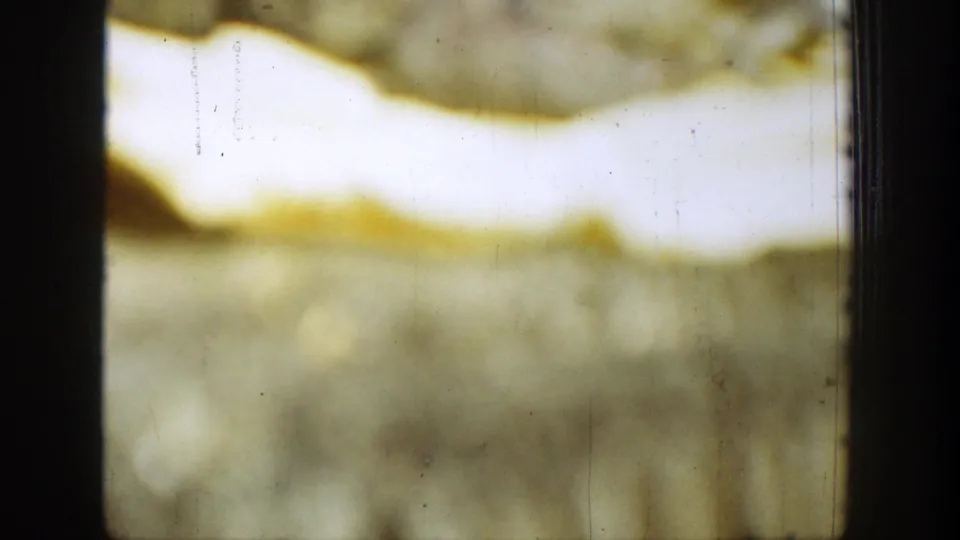 1939 Chelan 8mm close view with yellow fading, pale exposure, a dark vertical frame line, scratches, dust, and soft grain.