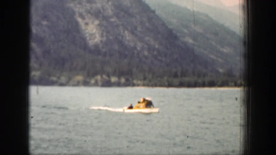 The boat appears closer in the 1939 Chelan footage, with a rider in yellow visible against the lake and mountain shoreline.