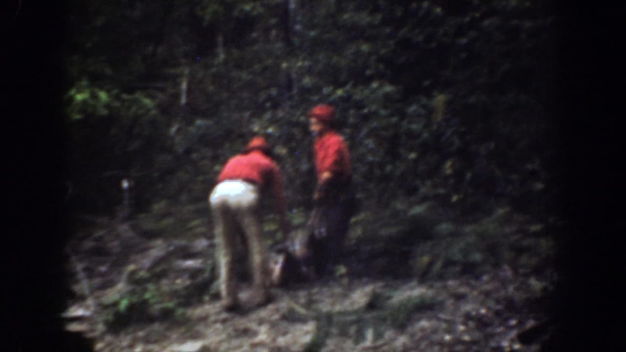 In the Chelan forest scene, one man bends near the animal carcass while another man in red stands watching or assisting.