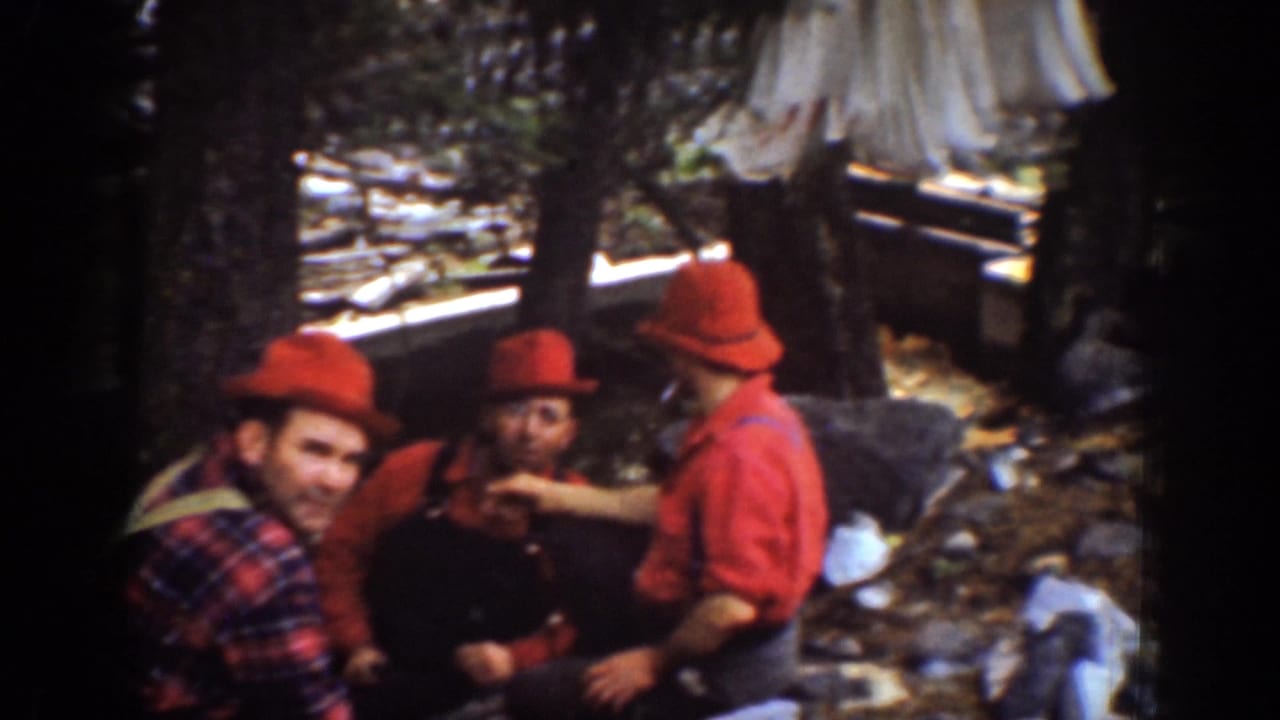 Chelan, Washington 1939 footage shows four lumberjack men in red hats sitting together during a forest work break.