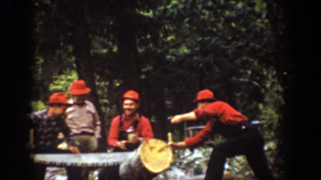 Four men in bright hats and red-toned clothing work around a large log in 1939 Chelan, Washington home-movie footage.
