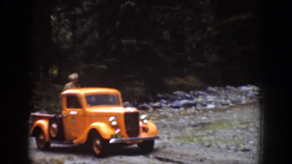 Yellow vintage pickup traveling on a rugged forest road in the 1939 Chelan, Washington footage.