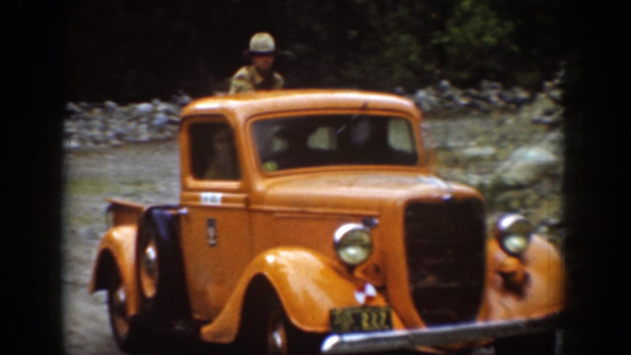 Closer 1939 Chelan frame of the yellow pickup with a person visible near or inside the cab.