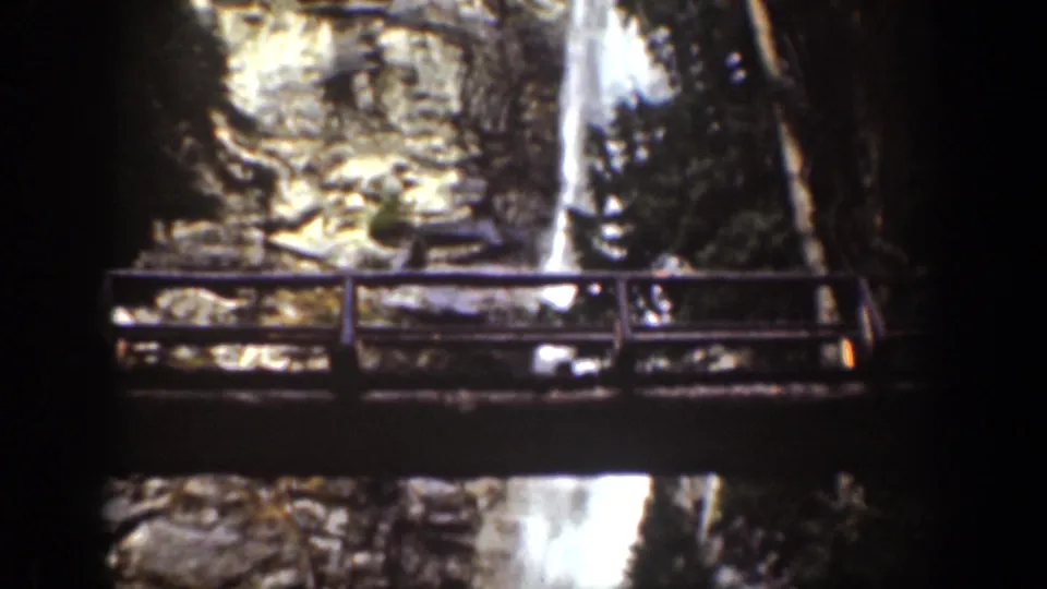 Wider 1939 Chelan waterfall view with a wooden bridge or overlook railing crossing the foreground.