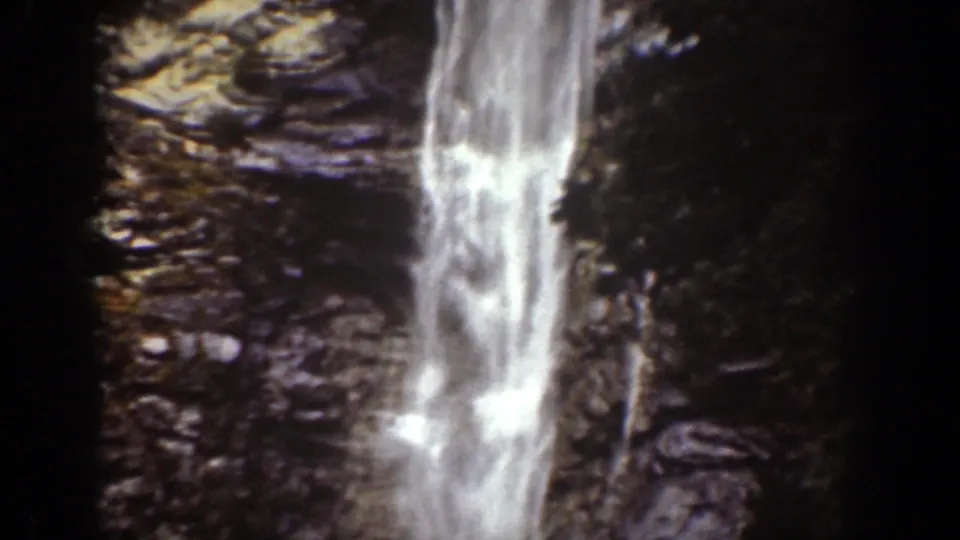 1939 Chelan, Washington 8mm frame showing white water falling past dark, textured rock in a narrow gorge.