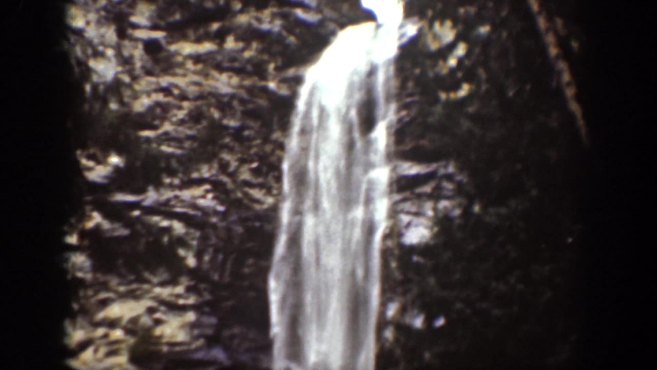 Chelan, Washington waterfall viewed on 1939 8mm film, with bright falling water against rugged dark rock.