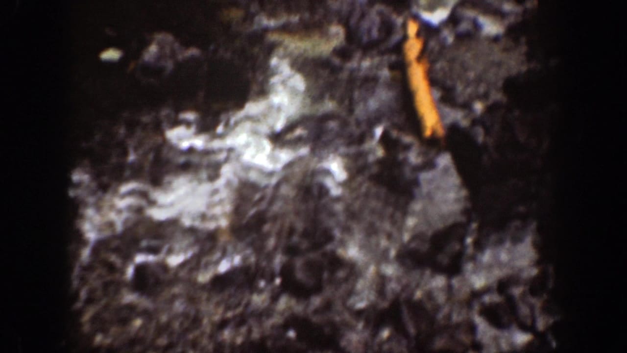 Foamy water moves across dark rocks in the Chelan waterfall footage, with a visible orange film artifact along the right edge.
