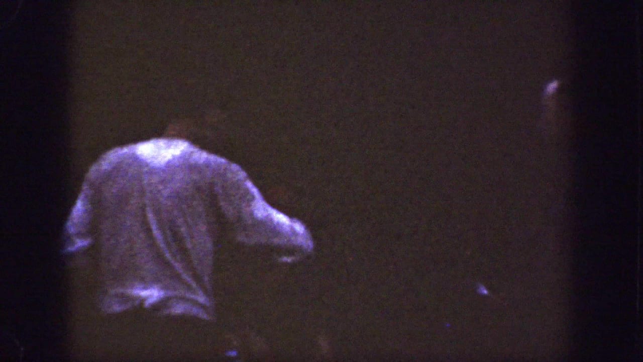 Dim 8mm frame showing a person from behind in low light.