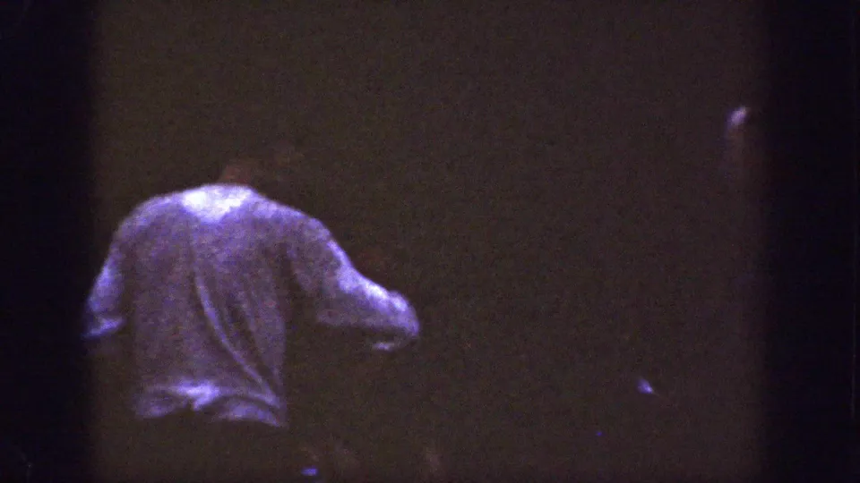 A dim 1939 8mm home-movie frame from Chelan, Washington, showing a person from behind in soft, underexposed light.