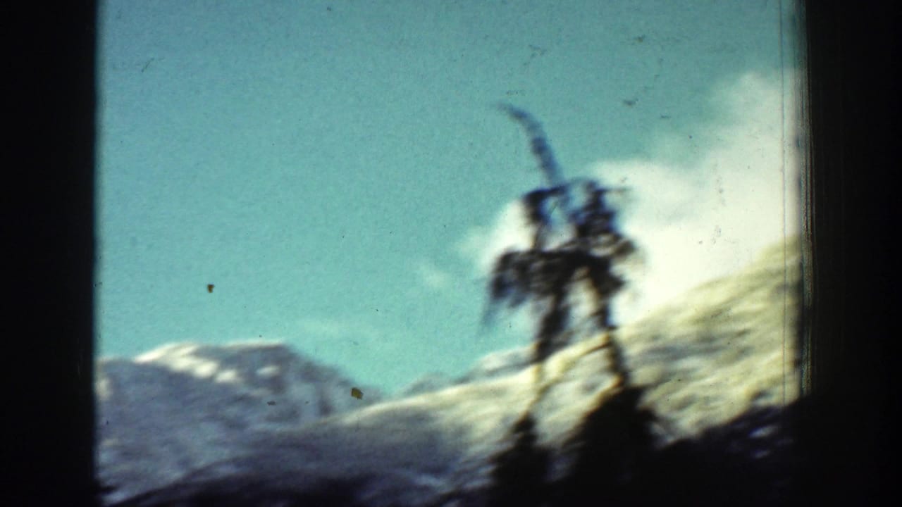 A distant figure stands on or near a snowy mountain summit in Chelan, Washington, filmed on 8mm in 1939.