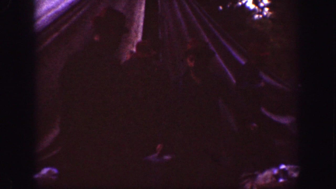 Chelan, Washington camping frame from 1939 showing tent fabric and indistinct figures in a very dark home-movie exposure.