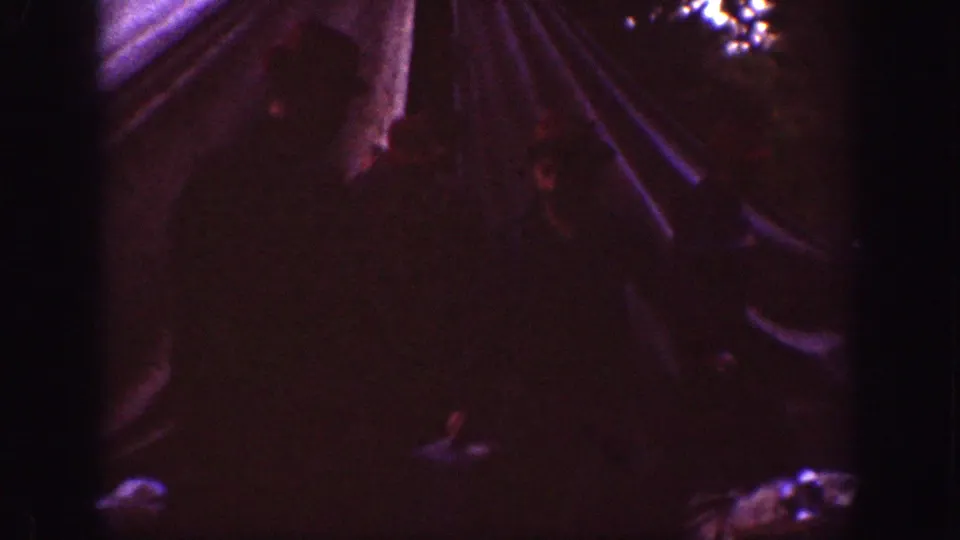 Chelan, Washington camping frame from 1939 showing tent fabric and indistinct figures in a very dark home-movie exposure.