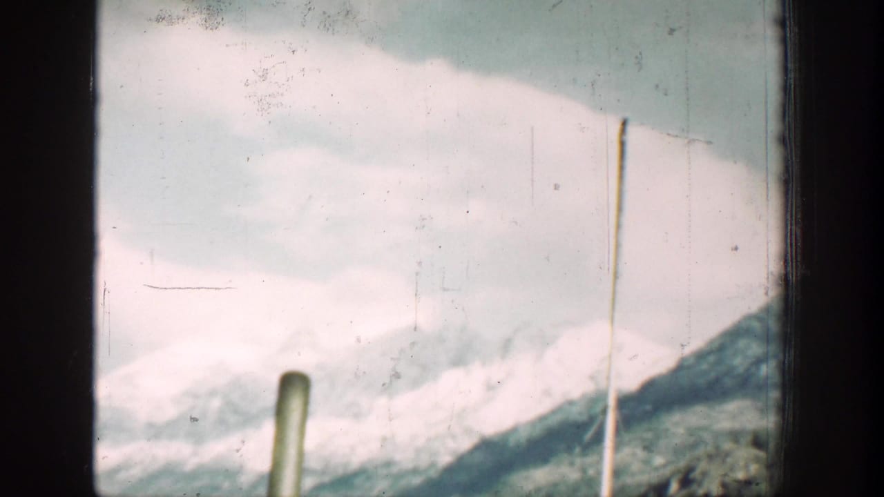 A pale snowy ridge and roadside poles pass through the Chelan-area vehicle-window view.