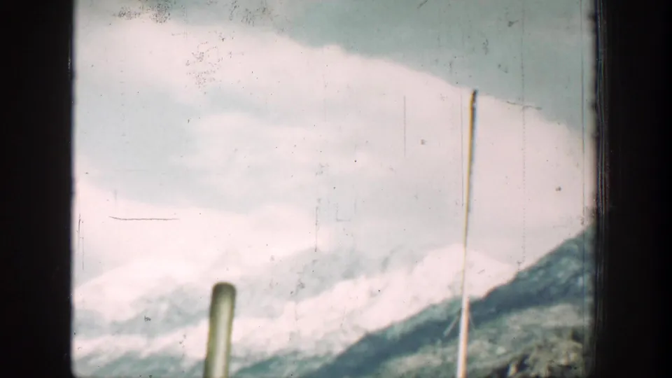 A pale snowy ridge and roadside poles pass through the Chelan-area vehicle-window view.