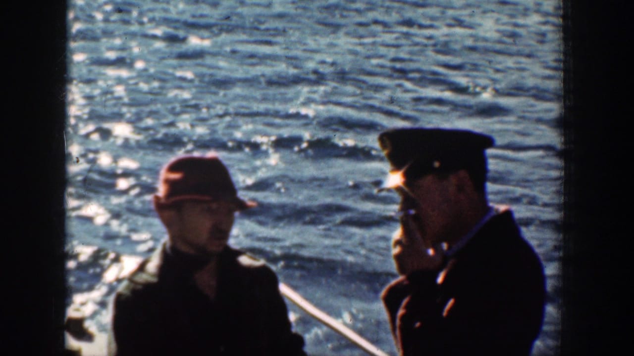 1939 Chelan, Washington home-movie frame showing two men conversing near a boat rail with bright water behind them.
