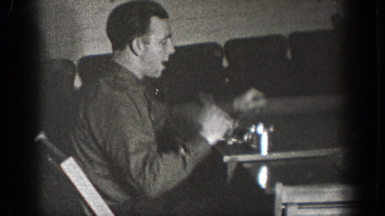 A man in profile sits at a table with cups and dishes in a private interior in Chelan, Washington footage from 1939.
