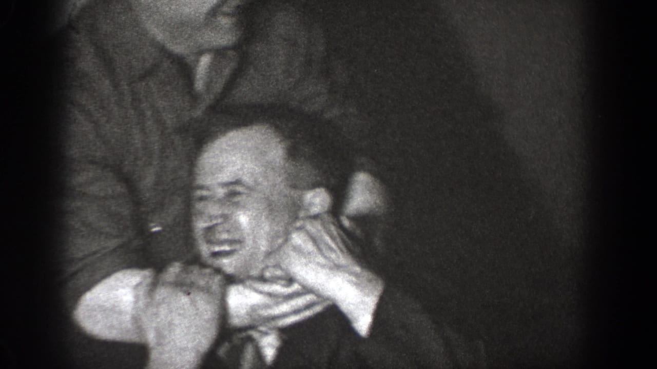In 1939 Chelan home-movie footage, adult men in suits appear to playfully restrain another man in a dark interior.