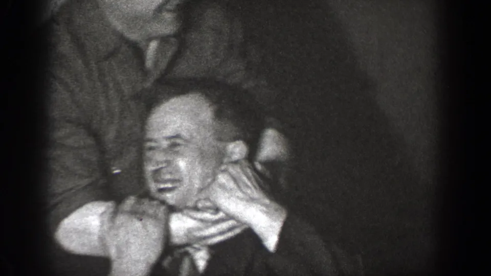 In 1939 Chelan home-movie footage, adult men in suits appear to playfully restrain another man in a dark interior.