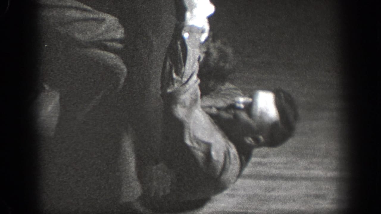 Chelan, Washington 1939 home-movie frame showing two adults on the floor during a close grappling practice moment.