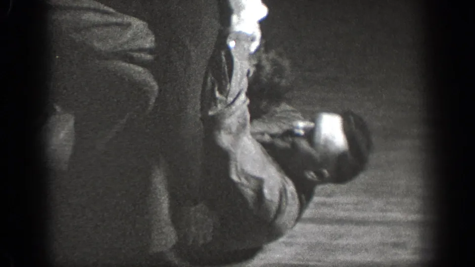 Chelan, Washington 1939 home-movie frame showing two adults on the floor during a close grappling practice moment.