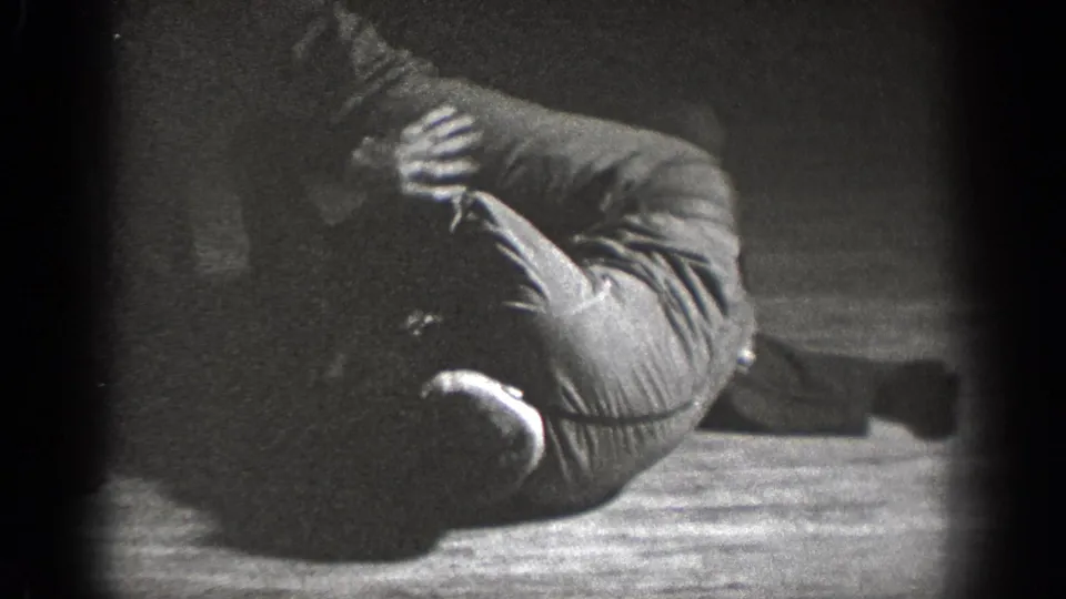 In 1939 Chelan home-movie footage, two adult men appear to wrestle playfully on a wooden floor in a dark interior.