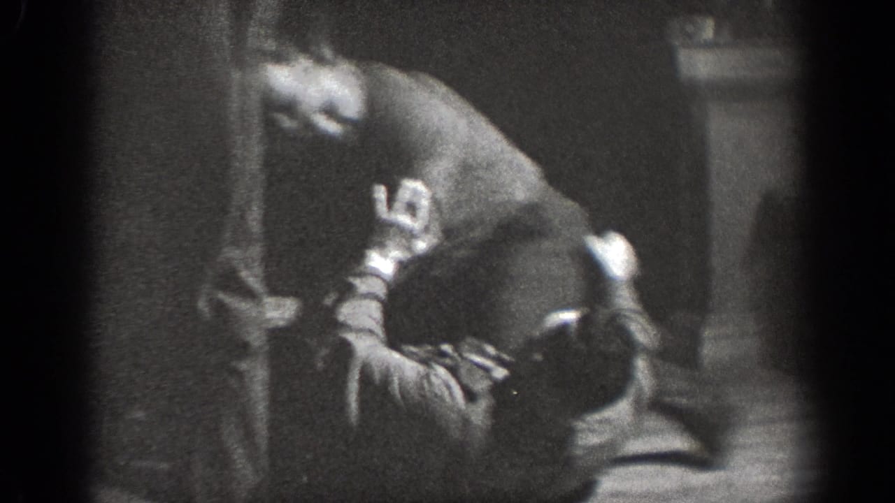 A man in casual clothes bends over another man on the floor while a third adult stands nearby in the Chelan interior.